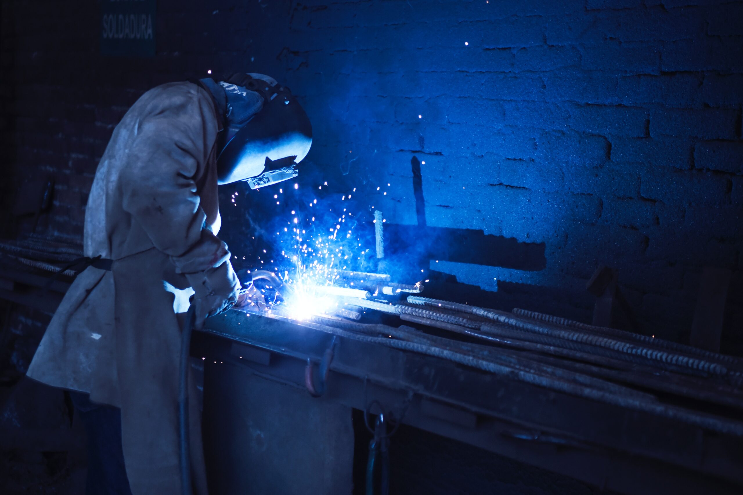 man-wearing-welding-helmet-welding-metal-near-gray-brick-1474993